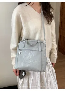 Detail der LOUISAMANI-Prägung auf der grauen Vintage-Umhängetasche aus Kunstleder