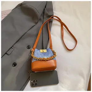Détails du mini sac seau en denim avec tissu matelassé et base en cuir marron