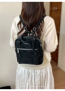 Detailansicht eines schwarzen Vintage-Rucksacks mit geprägter Textur und Schriftzug