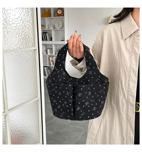 Dettaglio della borsa tote in velluto nero con motivi a cuore e doppie tasche frontali