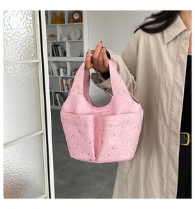 Dettaglio borsa hobo in tela rosa con stelle argento e pratiche tasche anteriori