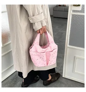 Dettaglio borsa a mano in tela rosa con stampe di stelle argentate e tasche multiple
