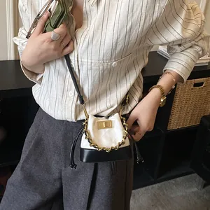 Mini sac seau matelassé en cuir noir et blanc avec décoration de chaîne dorée