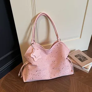 Sac fourre-tout rose à motif d'étoiles avec broderie et breloque dans un intérieur