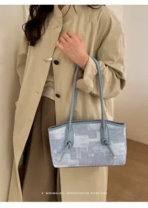 Détail du sac cabas bleu à motif marbre avec fine bandoulière et logo doré élégant