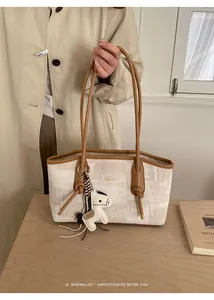 Détail du cabas minimaliste avec bordure en cuir et accessoire charm de cheval