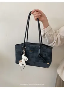 Détail d'un grand sac cabas gris imprimé avec charme cheval et marquage doré élégant