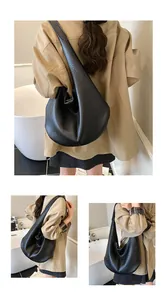 Close-up of black pebble grain leather texture on a spacious hobo shoulder bag