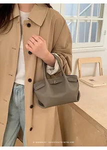 Detail of grey leather bucket bag with metallic buckle and soft lychee texture