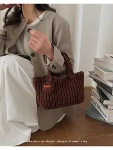 Bolso de mano de punto marrón con detalle de corazón hecho a mano en ambiente de moda