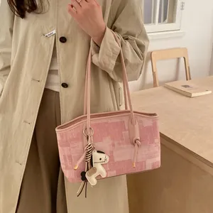 Cabas en toile rose à motif géométrique avec anses en cuir porté par un mannequin