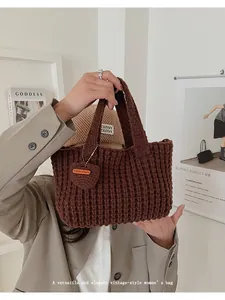 Detalle del bolso de punto marrón hecho a mano con textura de rayas y etiqueta