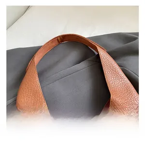 Detailed close-up of brown lychee texture leather shoulder strap with neat stitching