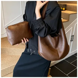 Detail of dark brown leather tote bag set featuring large capacity and matching pouch
