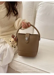 Brown litchi grain bucket bag with silver twist lock and plush bear charm detail