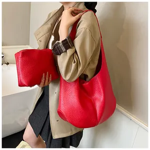 Detailed view of red lychee texture tote bag with matching pouch shown on shoulder