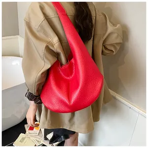 Detailed view of a red leather hobo bag showing large capacity and lychee grain texture