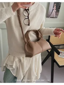Detailed close-up of a vintage taupe cloud bag with pleated leather and round top handle