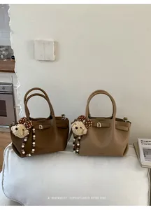 Detail of vintage bucket bags in brown and khaki with plush bear and bead chain charms
