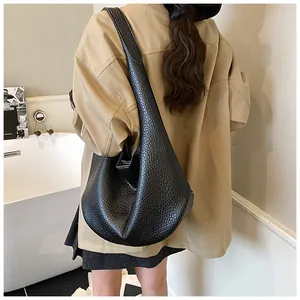 Detail of a large black hobo tote bag featuring premium lychee-grain leather texture