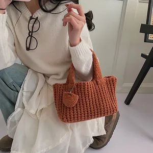Bolso de punto naranja hecho a mano con colgante de corazón y textura de punto