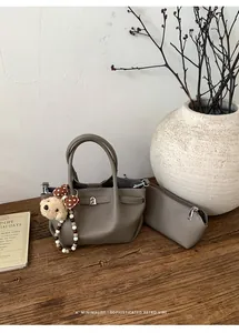 Detail of lychee pattern leather bucket bag with bear charm and matching pouch