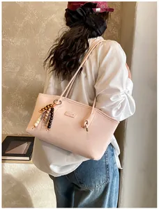 Detail of pink PU tote bag with CHUU logo and colorful wooden bead tassel accessory