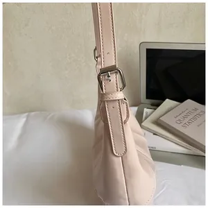 Detail of adjustable strap with silver buckle on pink pleated leather crossbody bag
