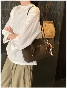 Detail of dark brown matte tote bag with bohemian bead tassel and CHUUDON patch logo