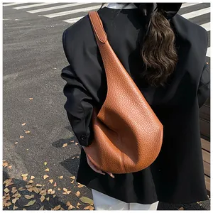 Close-up of caramel brown lychee leather hobo bag with seamless wide shoulder strap