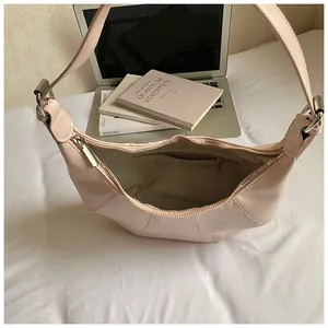 Detailed top view of beige hobo bag opening with zipper pocket and wide shoulder strap
