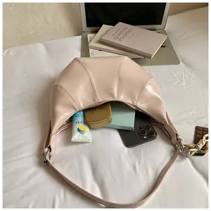 Detail of opened moon bag showing interior storage with phone and cosmetics