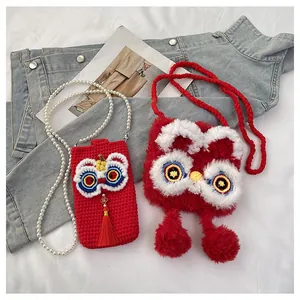Detail of red knitted lion dance bags with pearl straps and festive fringe accents