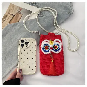 Detail of hand-knitted lion dance phone bag with pearl strap and lucky charm tassel