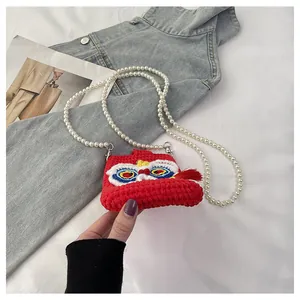 Close-up of a handmade crochet lion dance bag with pearls and festive embroidery