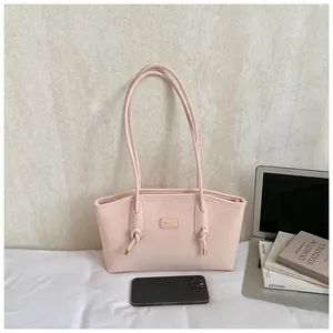 Detail view of pink tote bag showing the knotted shoulder strap and matte leather finish