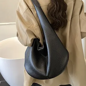 Minimalist black lychee pattern leather tote bag shown on model in a soft natural light