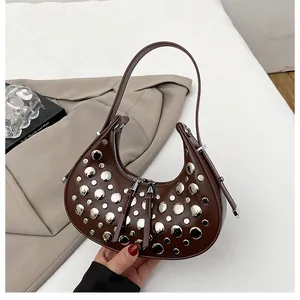 Detail of coffee brown hobo bag with silver studs and dual zipper closure system