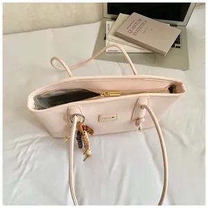 Top view of pink PU leather tote bag with gold zipper and wooden bead charm detail