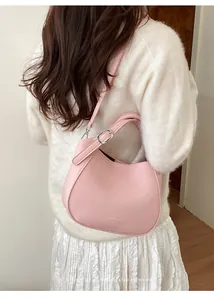 Détail d'un sac seau en cuir grainé rose avec boucle argentée et logo discret