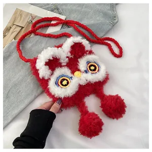 Close-up of fluffy red knit crossbody bag with lion dance embroidery and soft pom-poms