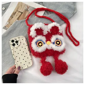 Detail of red plush lion dance crossbody bag with embroidered eyes and pompom charms