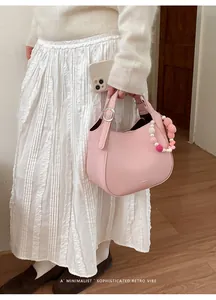 Sac seau rose en cuir grainé avec un charme de perles colorées en forme de cœur