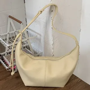 Chic creamy yellow crescent hobo bag with textured leather and knotted shoulder strap