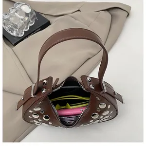 Top view of dark brown crescent bag with silver rivets showing daily interior storage space