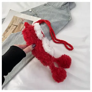 Detailed macro view of the festive red and white knitted bag with soft plush pom-pom details