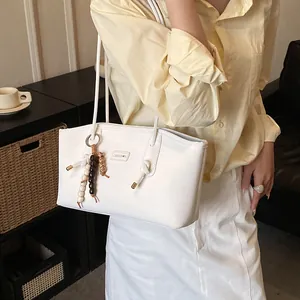 Minimalist white tote bag with bohemian beaded tassel and metal logo for daily use