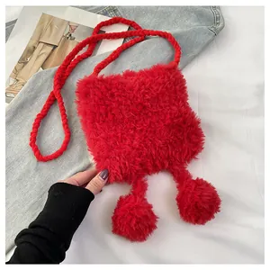 Detail of red knitted lion dance style plush crossbody bag with furry pompoms
