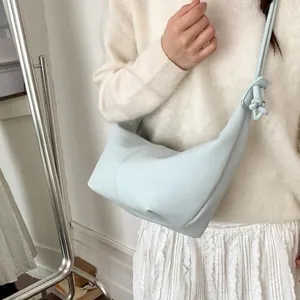 Minimalist light blue pleated crescent shoulder bag with decorative knot strap detail