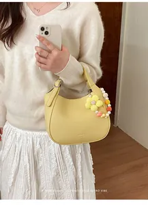 Détail du sac seau en cuir jaune avec breloque tournesol et chaîne de perles